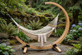 Bamboo arc hammock stand for a single hammock on a stone patio