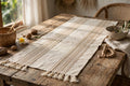 Handwoven natural cotton table runner on a rustic wooden dining table